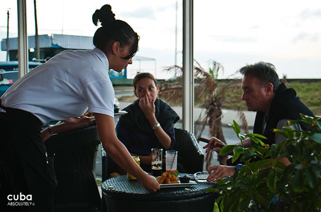 female waiter serving to a couple in 3d club in Vedado © Cuba Absolutely, 2014