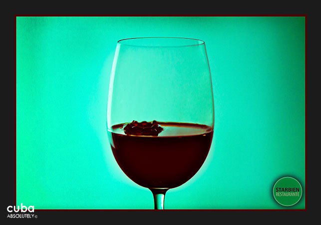 Glass of wine in  front of a green wall© Cuba Absolutely, 2014