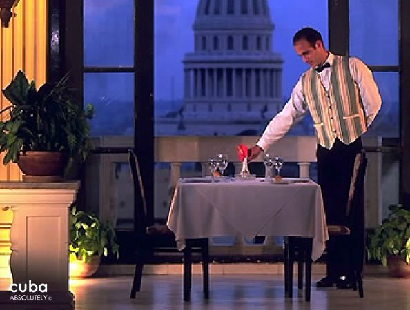 Waiter putting a red flower on a table © Cuba Absolutely, 2014