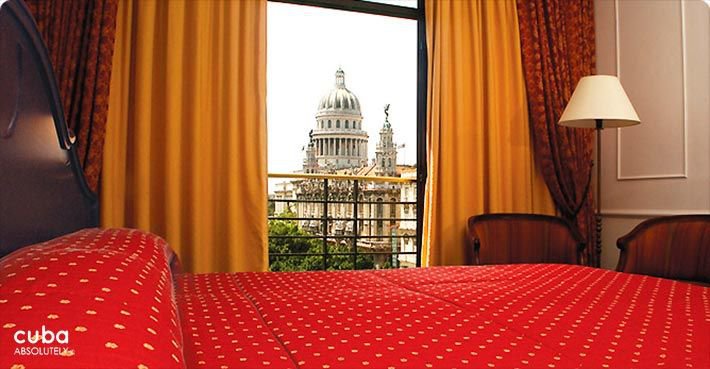 Parque Central hotel in Old Havana, view of the capitolio from a room with orange curtains and red bed © Cuba Absolutely, 2014 - 2020