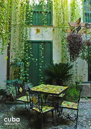 Valencia Hotel in Old Havana, iron chairs with green details under plants  © Cuba Absolutely, 2014 - 2020