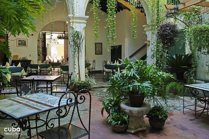 Valencia Hotel in Old Havana, iron table and chairs with color details at the interior yard © Cuba Absolutely, 2014 - 2020