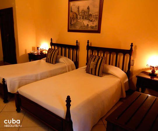 O´Farrill Palace hotel in Old Havana, room in orange with white bed  © Cuba Absolutely, 2014 - 2020