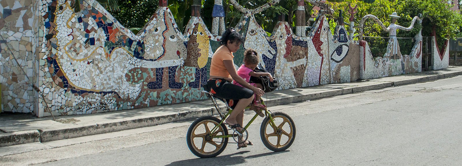 Woman on a bycicle carrying a child