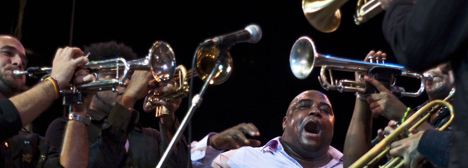 Alexander Abreu surround by trumpets on a Jazz festival