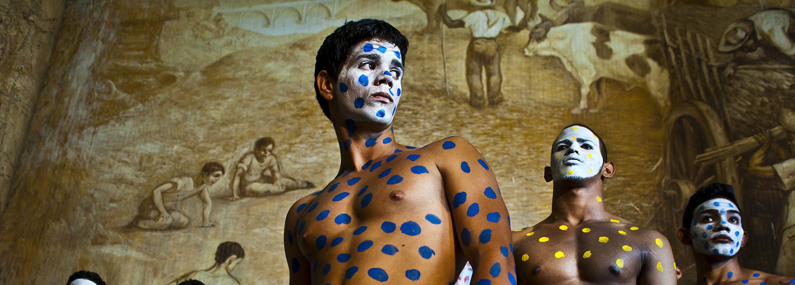 Models painted with blue and yellow spots and the face white