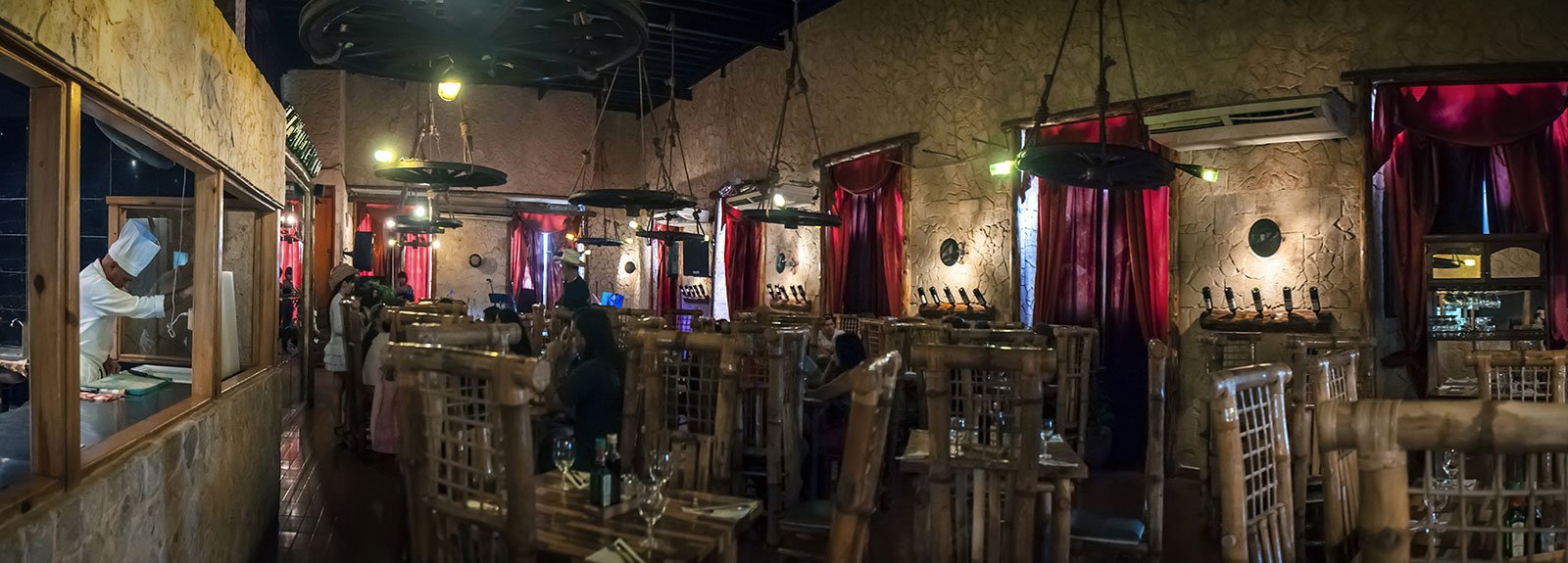 Tablao de Pancho restaurant in Old Havana, wood decoration like a rustic countryside place, band playing and people eating , waiter wearing hats