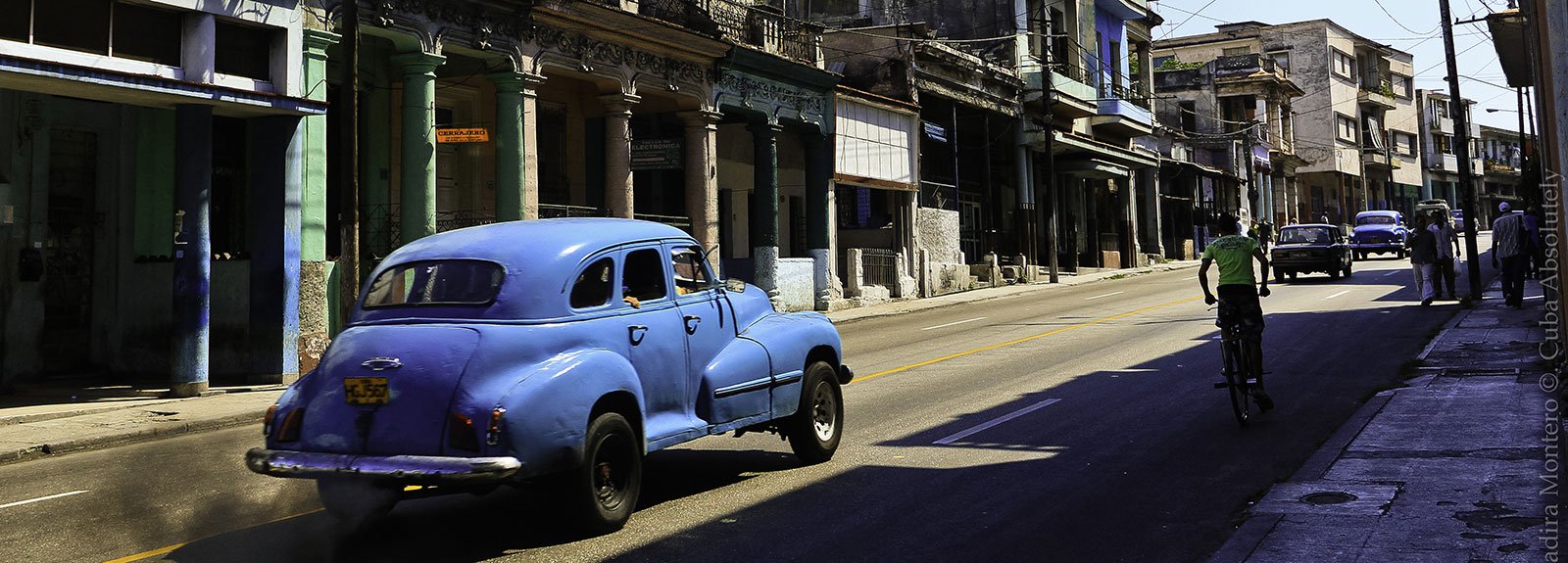 Blue car passing by a street