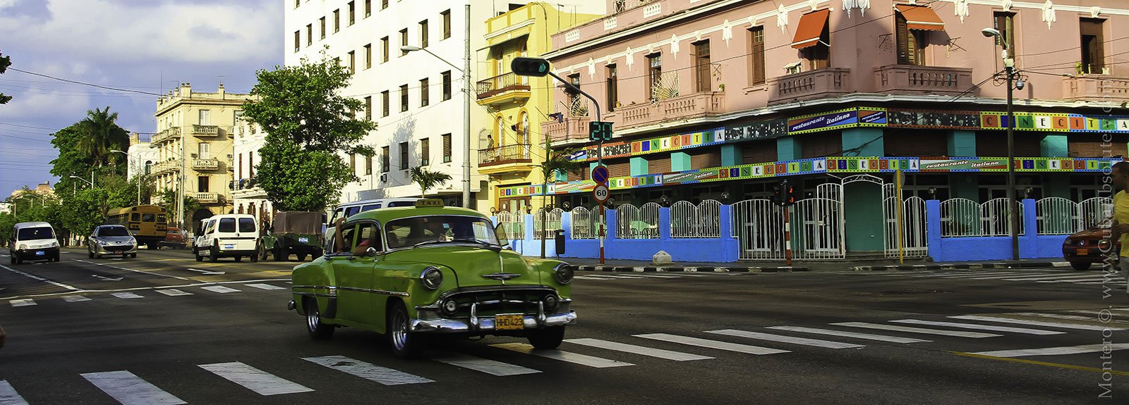 Green old car passing by the street